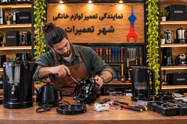 تعمیرکار در حال بررسی سماور برقی نوردیا Nordia